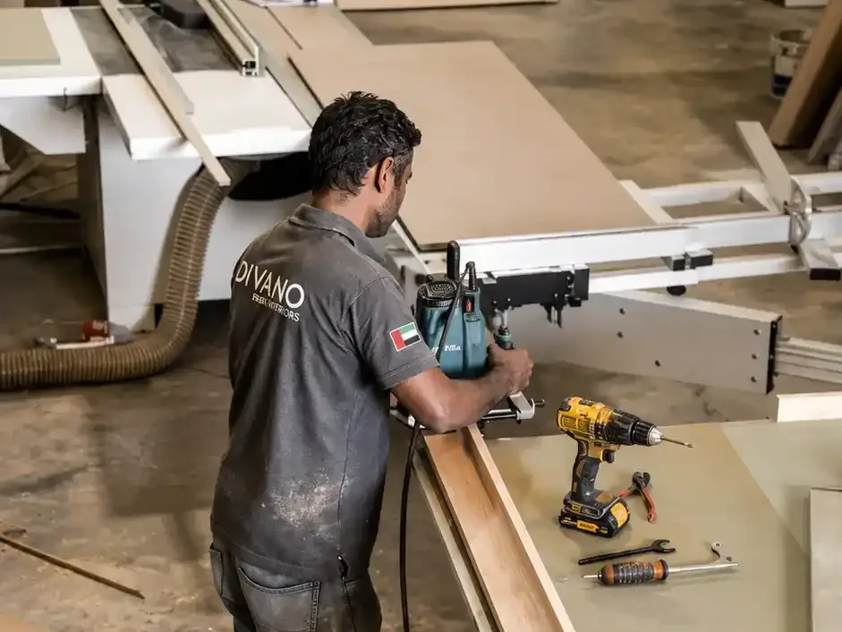 Divano craftsman machining a timber profile at the panel saw in our Dubai workshop